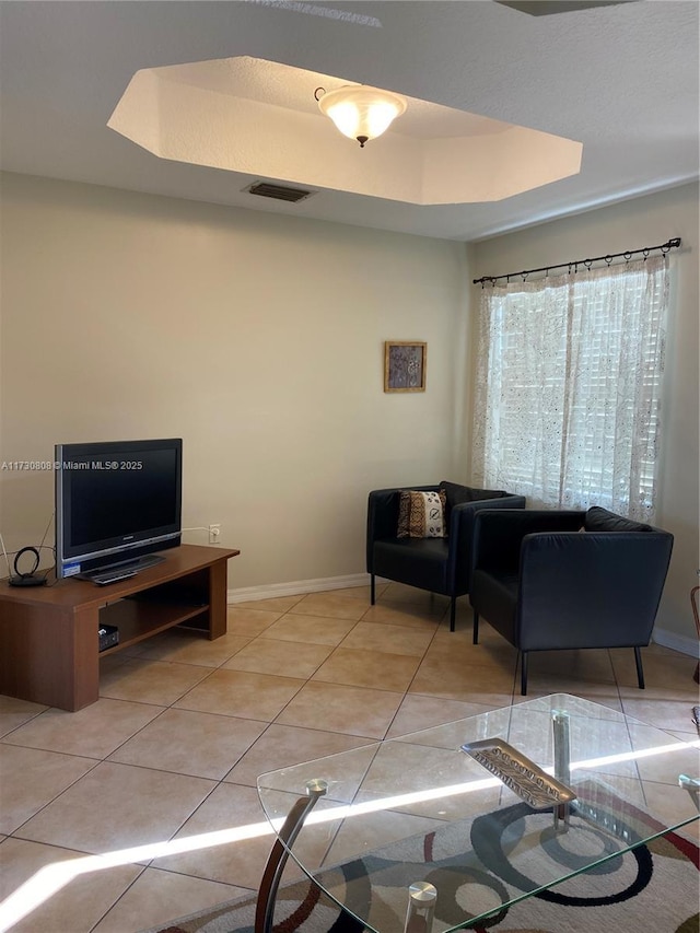 tiled living room with a tray ceiling