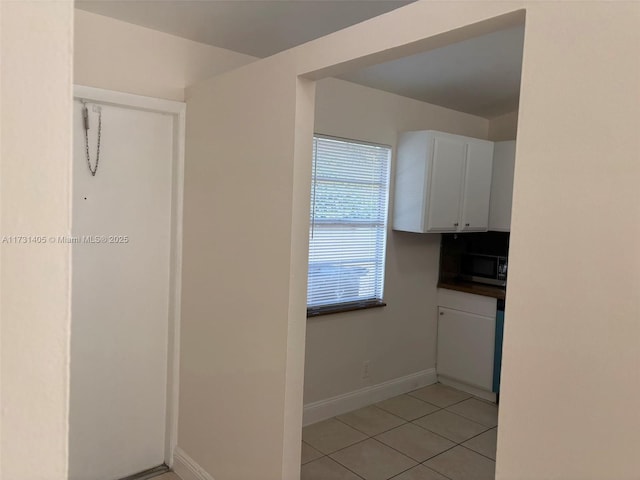 kitchen with light tile patterned floors and white cabinets