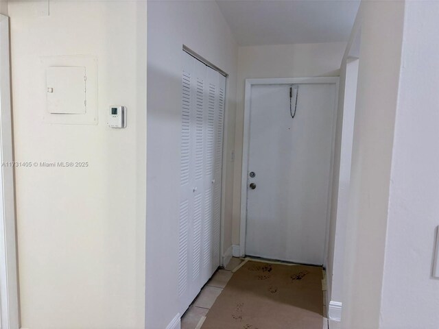 doorway with light tile patterned floors and electric panel