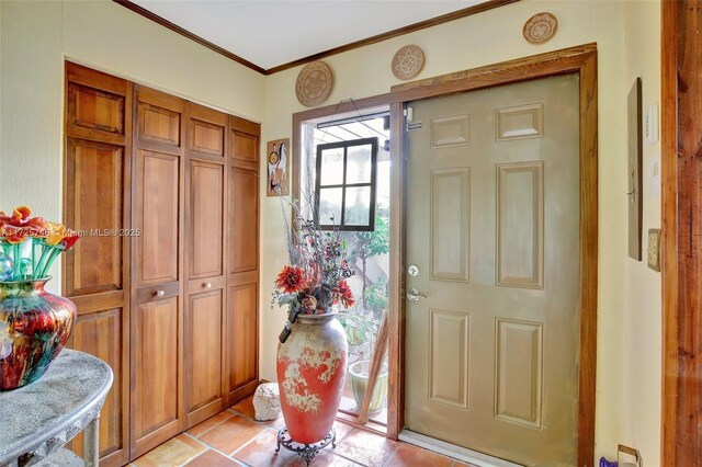 entryway featuring light tile patterned floors and ornamental molding