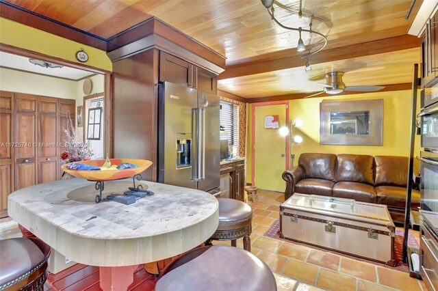 tiled dining space with wooden ceiling and ceiling fan