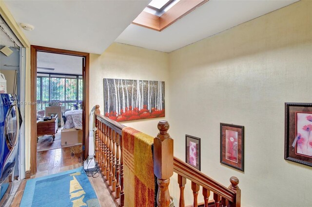 corridor featuring light tile patterned floors and a skylight