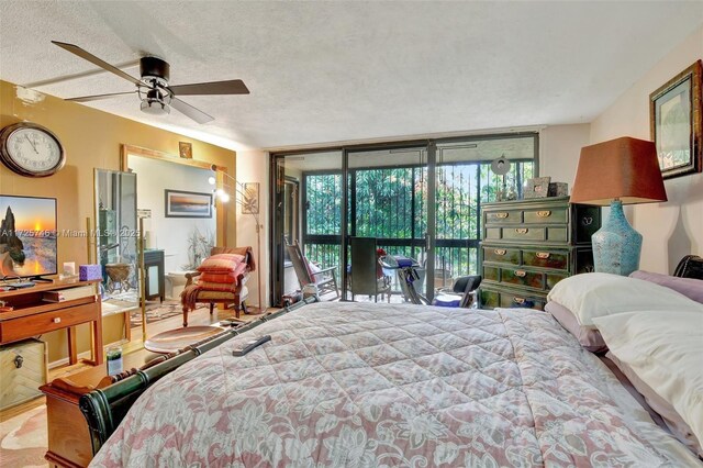 bedroom featuring expansive windows, ceiling fan, a textured ceiling, and access to outside