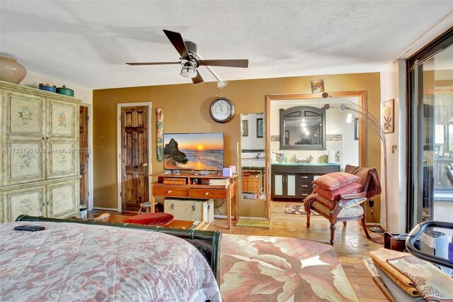 bedroom with ceiling fan, a textured ceiling, and light hardwood / wood-style flooring