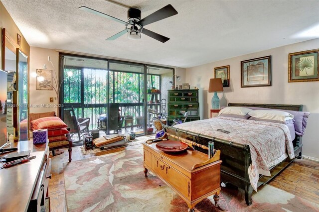 bedroom with expansive windows, access to exterior, a textured ceiling, and ceiling fan