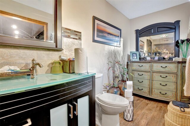 bathroom featuring tasteful backsplash, vanity, and toilet