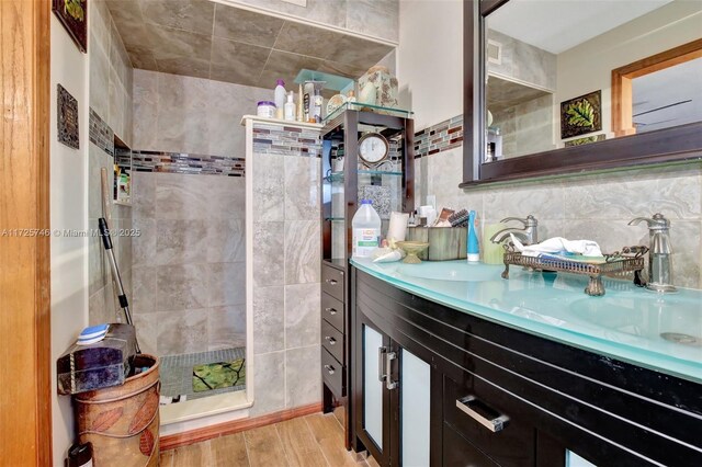 bathroom featuring tasteful backsplash, vanity, and tile walls