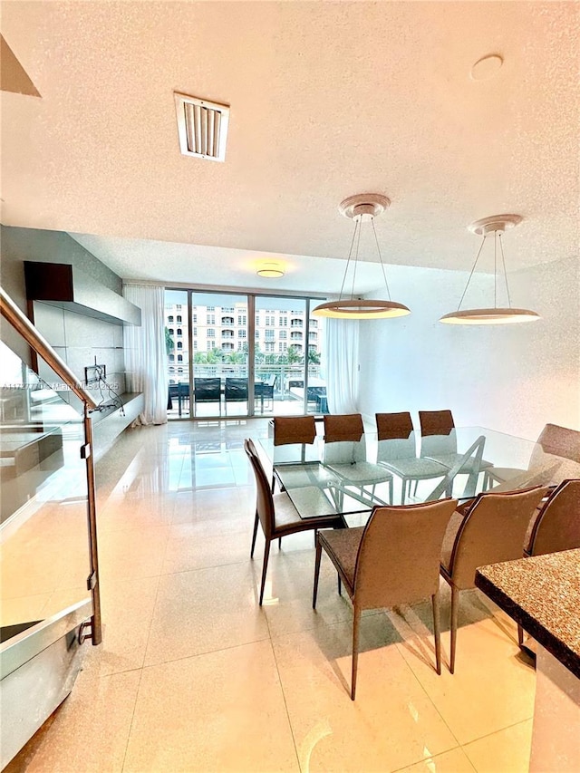 dining area featuring floor to ceiling windows and a textured ceiling