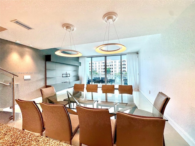 dining space featuring a wall of windows and a textured ceiling