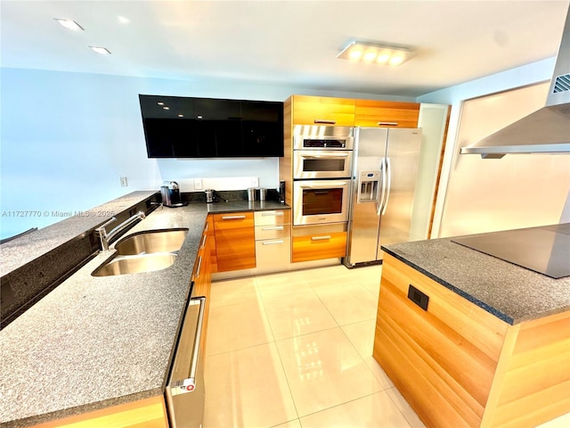 kitchen featuring sink, light tile patterned floors, appliances with stainless steel finishes, ventilation hood, and dark stone counters