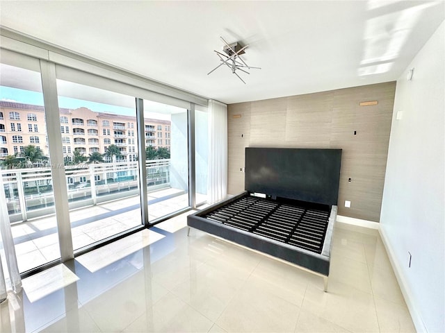 unfurnished bedroom featuring expansive windows, access to outside, and light tile patterned floors