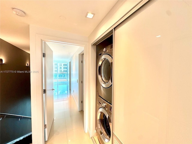 washroom featuring stacked washer / drying machine and light tile patterned floors