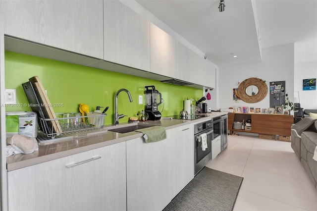 kitchen featuring light tile patterned flooring, black electric stovetop, oven, and sink