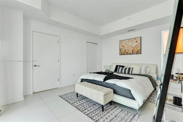 tiled bedroom with a tray ceiling