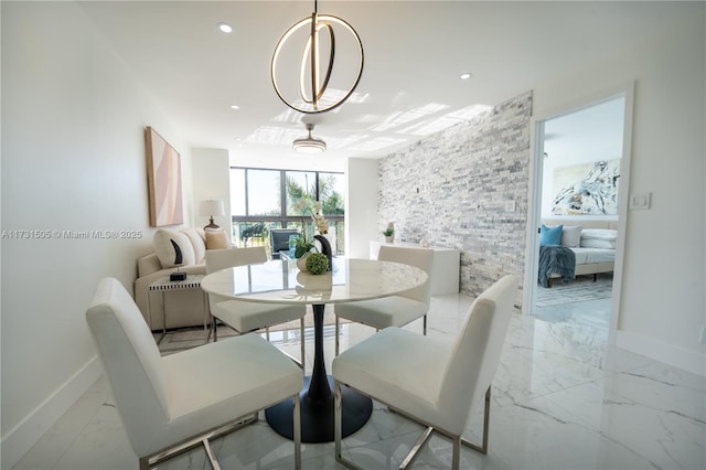 dining area featuring an inviting chandelier and a wall of windows