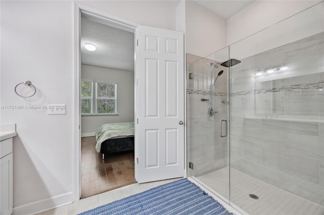 bathroom featuring vanity, an enclosed shower, tile patterned flooring, and a textured ceiling