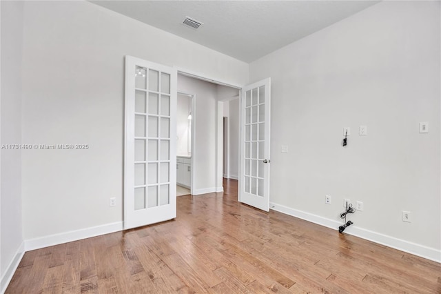 unfurnished room featuring light wood-type flooring and french doors