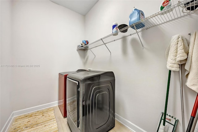 washroom with washing machine and clothes dryer and light wood-type flooring