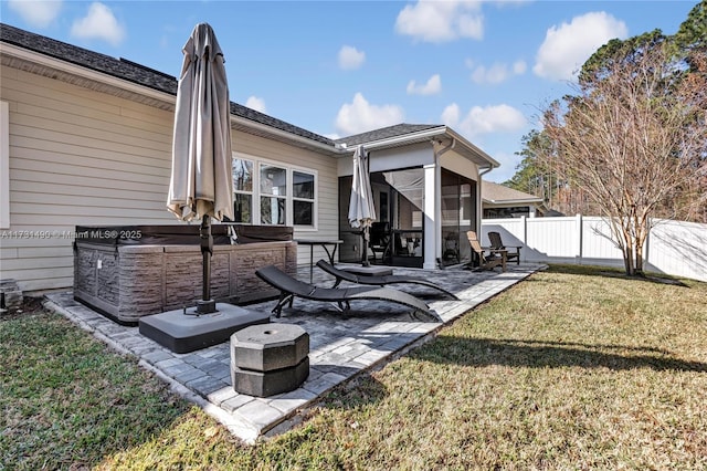 view of patio / terrace featuring a hot tub and a sunroom