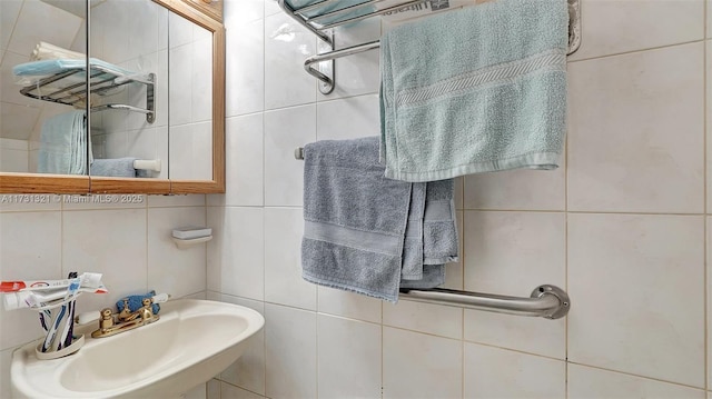 bathroom with sink and tile walls