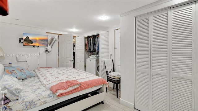 tiled bedroom with ornamental molding and washer / dryer