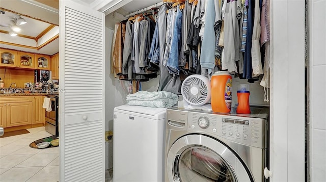 laundry area with crown molding, independent washer and dryer, light tile patterned flooring, and sink