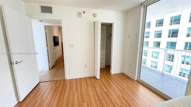 unfurnished bedroom featuring light hardwood / wood-style flooring and access to outside