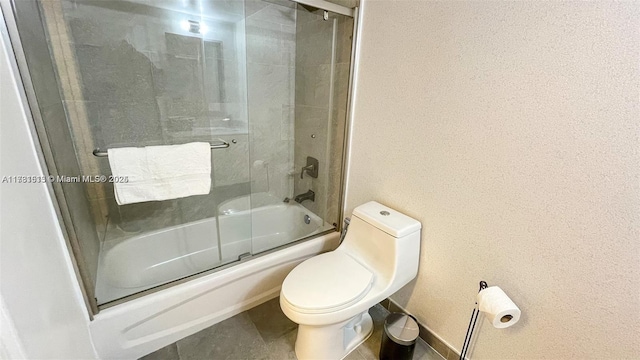 bathroom featuring bath / shower combo with glass door and toilet