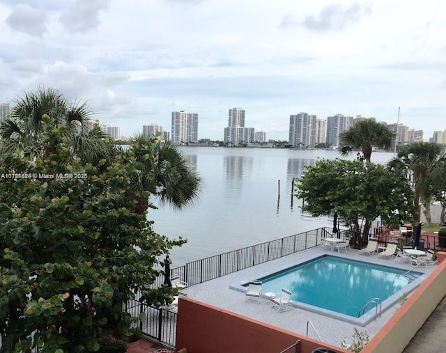 view of swimming pool featuring a patio and a water view