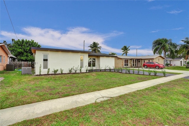 single story home featuring central AC unit and a front lawn