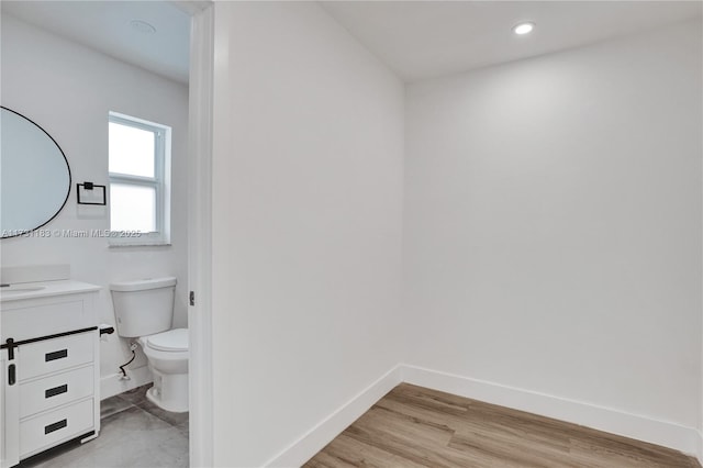 bathroom featuring vanity, toilet, and wood-type flooring