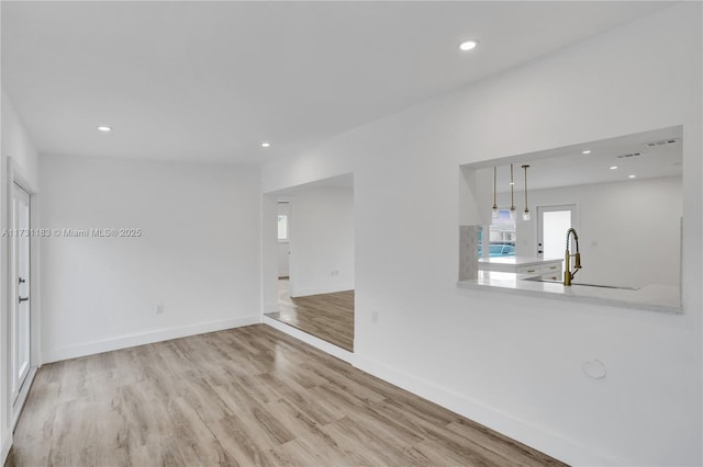 spare room with sink and light hardwood / wood-style flooring