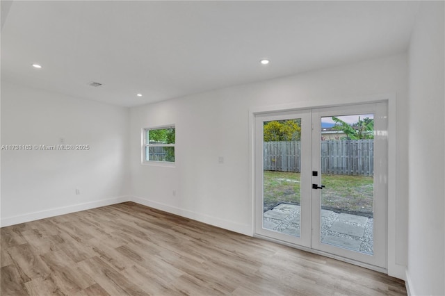 unfurnished room featuring french doors and light wood-type flooring