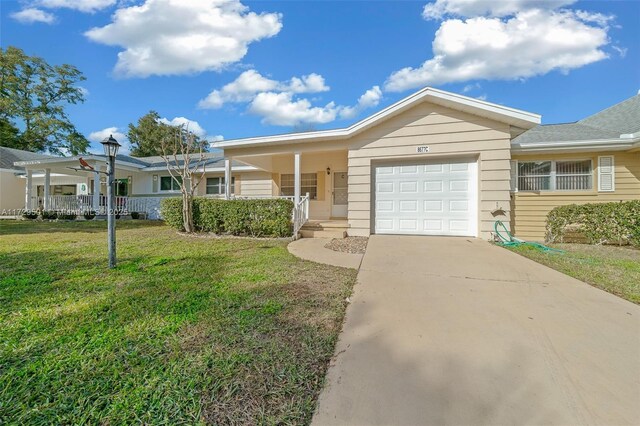 single story home featuring a garage, a porch, and a front yard