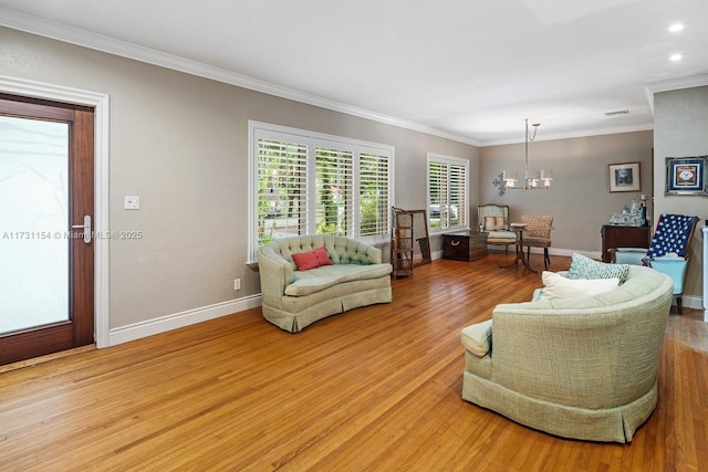 living room with crown molding, hardwood / wood-style flooring, and a chandelier