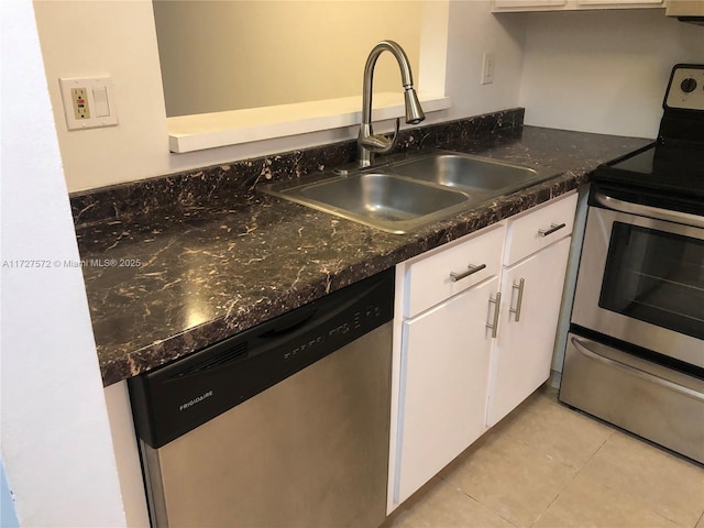 kitchen with light tile patterned flooring, stainless steel appliances, sink, and white cabinets