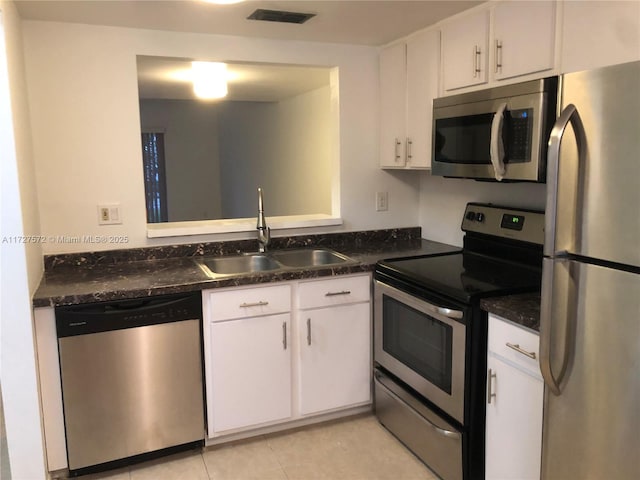 kitchen featuring sink, stainless steel appliances, white cabinets, and light tile patterned flooring