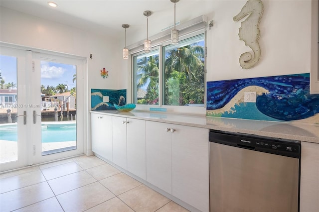 kitchen with white cabinetry, stainless steel dishwasher, light tile patterned flooring, and pendant lighting