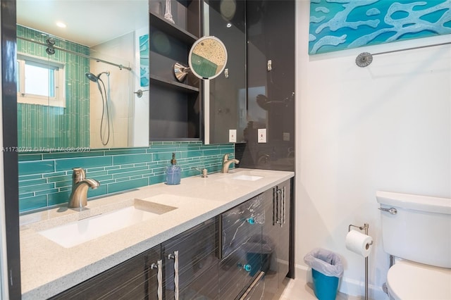 bathroom featuring tasteful backsplash, vanity, toilet, and a tile shower