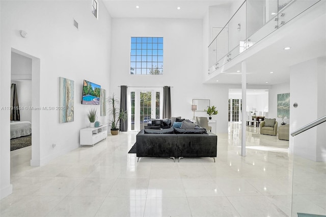 living room with french doors and a towering ceiling