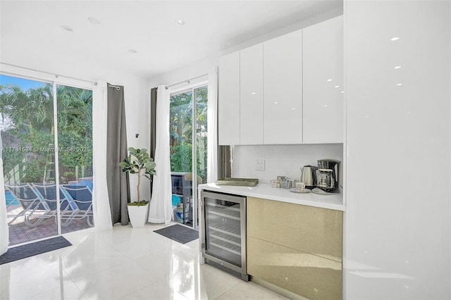 bar featuring white cabinetry, floor to ceiling windows, beverage cooler, and light tile patterned flooring