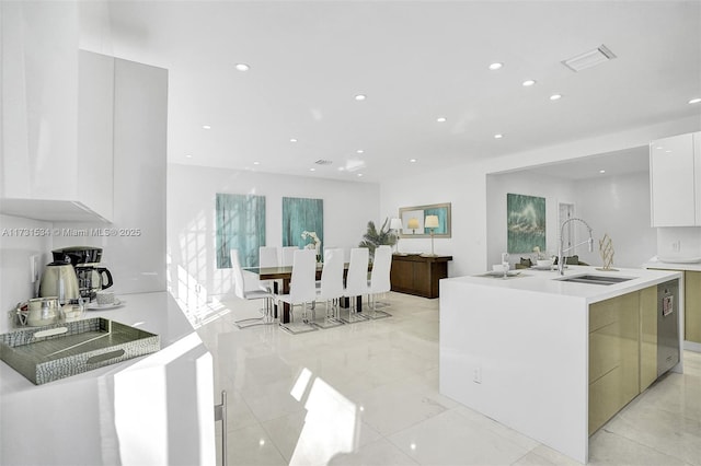 kitchen featuring a center island with sink, sink, light tile patterned floors, and white cabinets