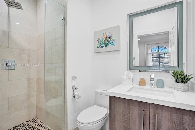 bathroom featuring tiled shower, vanity, and toilet