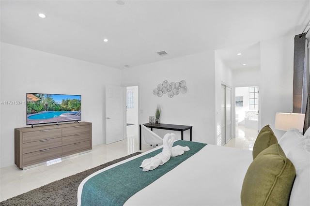 bedroom with connected bathroom and light tile patterned floors