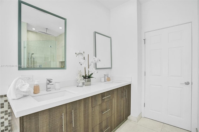 bathroom with a shower with door, vanity, and tile patterned floors