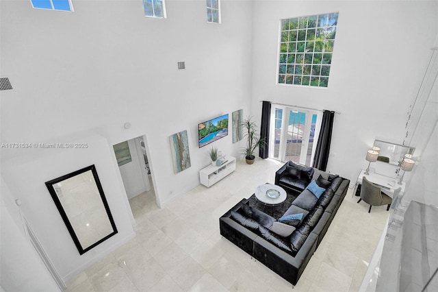 living room with light tile patterned floors and a towering ceiling