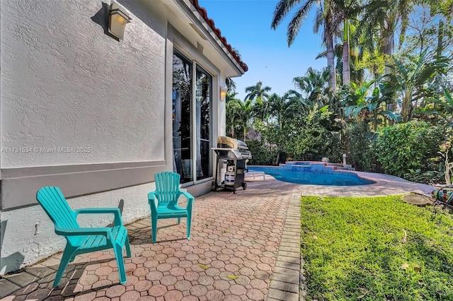 view of pool with a grill, a patio area, and an in ground hot tub