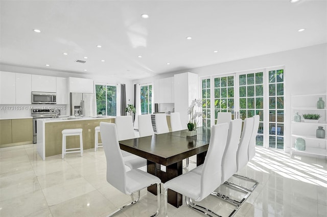 dining space featuring sink and light tile patterned floors