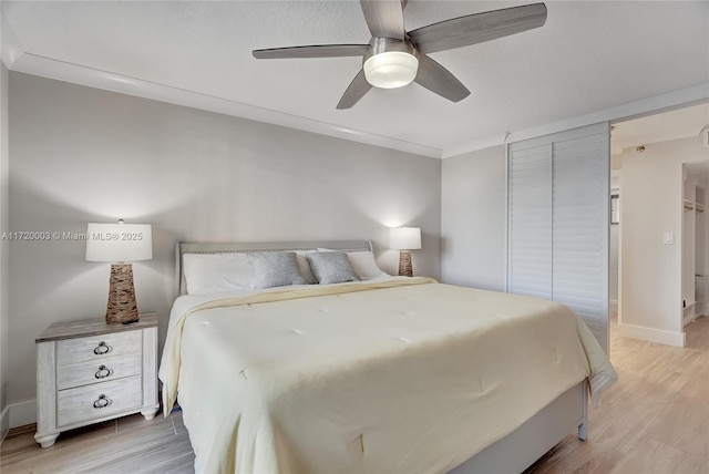 bedroom with crown molding, ceiling fan, and light hardwood / wood-style floors