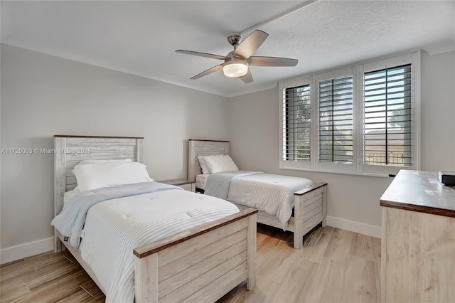 bedroom featuring a textured ceiling, light hardwood / wood-style floors, and ceiling fan